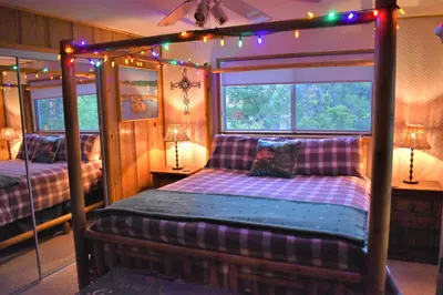 a bedroom with two beds and a window with christmas lights at Dream Getaway-Secluded Hot Spa-Walk to Village-Walk to Pineknot Trailhead-Plus King Bed! in Big Bear Lake