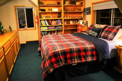 a bedroom with a bed and a book shelf at Dream Getaway-Secluded Hot Spa-Walk to Village-Walk to Pineknot Trailhead-Plus King Bed! in Big Bear Lake