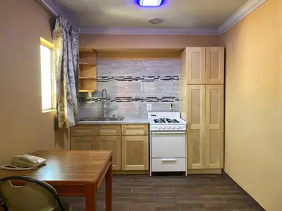 a kitchen with a stove and a sink and a table at Villa Park Motel in Orange