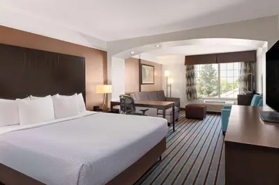 a hotel room with a bed and a desk at La Quinta by Wyndham Bakersfield North in Bakersfield