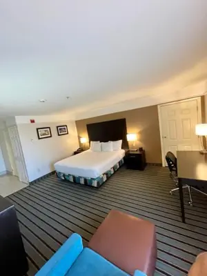 a hotel room with a bed and a table and chairs at La Quinta by Wyndham Bakersfield North in Bakersfield