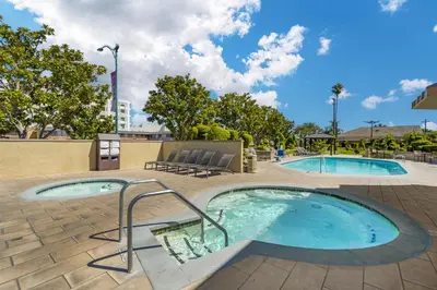 a pool with two chairs and two swimming pools at Best Western Plus Stovall's Inn in Anaheim