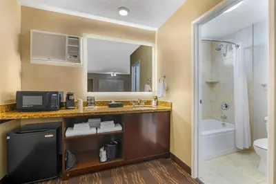 a bathroom with a sink and a toilet and a tub at Best Western Plus Stovall's Inn in Anaheim