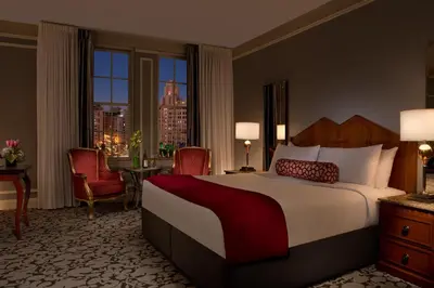 a bedroom with a large bed with a view of a city at The Biltmore Los Angeles in Los Angeles