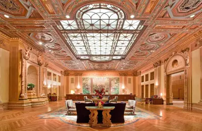 an ornate lobby with a large ceiling and a table at The Biltmore Los Angeles in Los Angeles