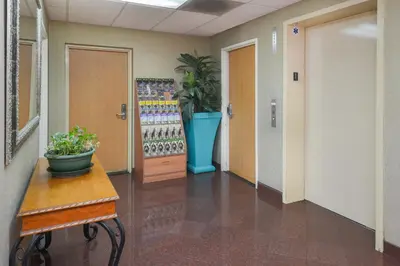 a hallway in a office with a potted plant at H3 Inn & Suites - LAX Airport - Los Angeles in Inglewood