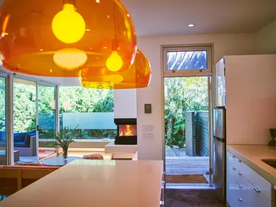 an orange pendant light in a kitchen with a living room at Palms Place in Los Angeles
