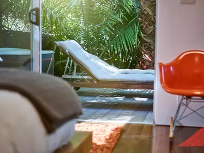 a porch with a swing and a red chair at Palms Place in Los Angeles