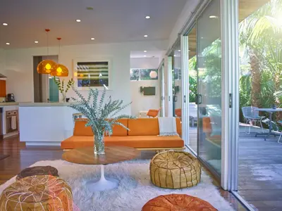 a living room with an orange couch and a table at Palms Place in Los Angeles