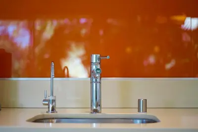 a bathroom sink with a faucet in front of a mirror at Palms Place in Los Angeles