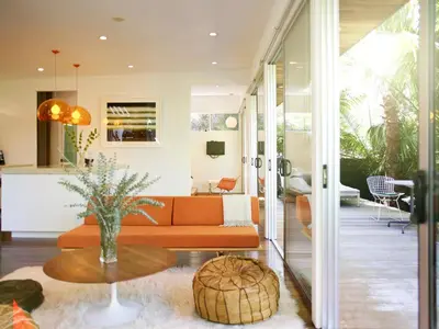 a living room with an orange couch and a table at Palms Place in Los Angeles