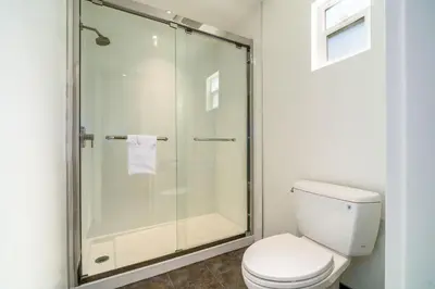 a bathroom with a toilet and a glass shower at Trend Hotel at LAX Airport in Inglewood