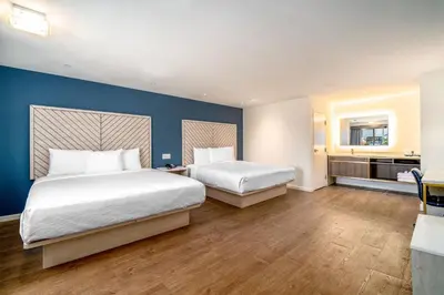 a bedroom with two beds and a blue wall at Trend Hotel at LAX Airport in Inglewood