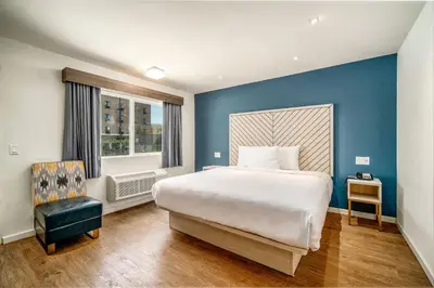 a bedroom with a large bed and a blue wall at Trend Hotel at LAX Airport in Inglewood