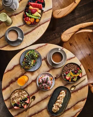a table with plates of food and cups of coffee at Santa Monica Proper Hotel, a Member of Design Hotels in Los Angeles
