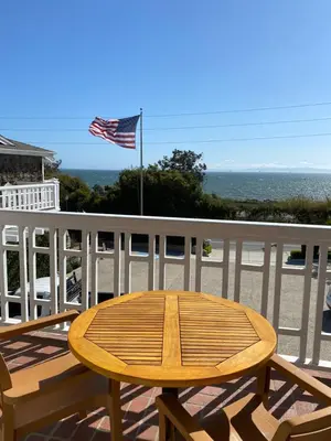 a wooden table on a balcony with an american flag at Inn On SummerHill in Summerland