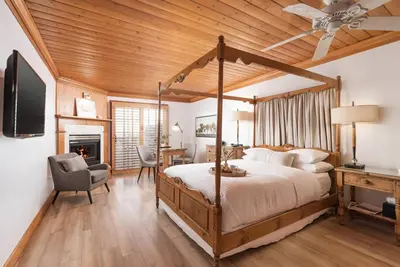 a bedroom with a canopy bed and a desk at Inn On SummerHill in Summerland