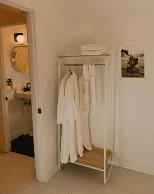 a rack of white clothes in a bathroom at Colorado Lodge in Big Bear Lake