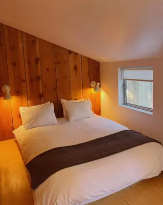 a bedroom with a large white bed with a window at Colorado Lodge in Big Bear Lake