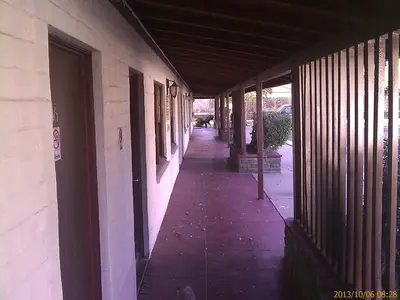 an empty hallway of a building with a sidewalk at Ranch Motel in Tehachapi