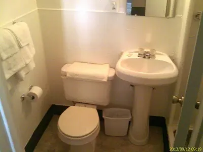 a small bathroom with a toilet and a sink at Ranch Motel in Tehachapi
