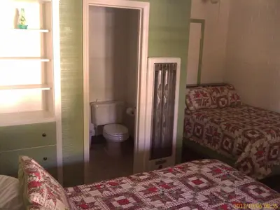 a room with a bed and a toilet in a room at Ranch Motel in Tehachapi