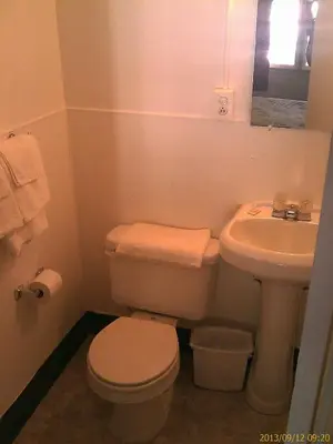 a small bathroom with a toilet and a sink at Ranch Motel in Tehachapi