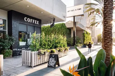 a coffee shop with plants in front of it at The LINE Hotel LA in Los Angeles