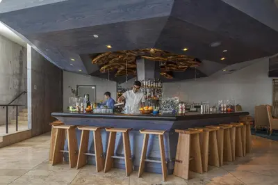 a man standing at a bar in a restaurant at The LINE Hotel LA in Los Angeles