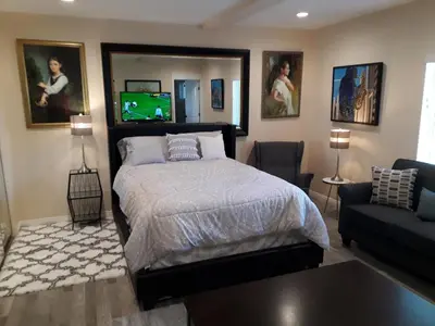 a bedroom with a bed and a couch and a tv at Comfortable Luxury Studio in Los Angeles