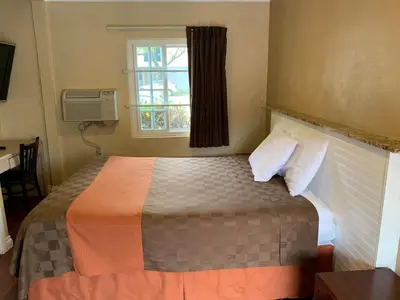 a bedroom with a large bed with a window at SunLight Motel Long Beach in Long Beach