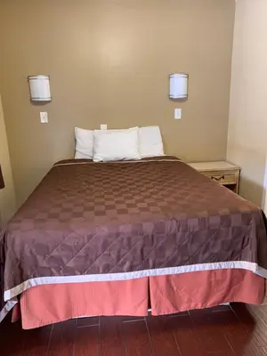 a bedroom with a large bed with two pillows at SunLight Motel Long Beach in Long Beach