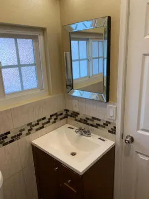 a bathroom with a sink and a mirror at SunLight Motel Long Beach in Long Beach