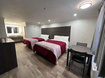 a hotel room with two beds and a table at Cloud 9 Inn LAX in Inglewood