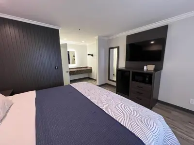 a bedroom with a large bed and a flat screen tv at Cloud 9 Inn LAX in Inglewood