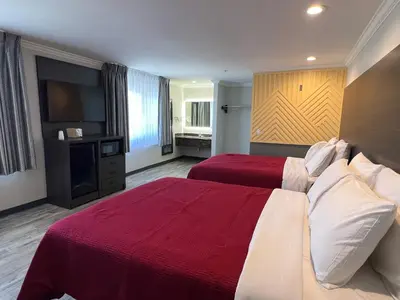 a hotel room with two beds and a flat screen tv at Cloud 9 Inn LAX in Inglewood