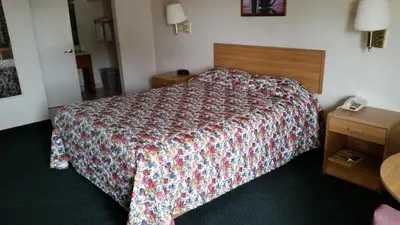 a hotel room with a bed and a telephone at Economy Inn Motel in Sylmar