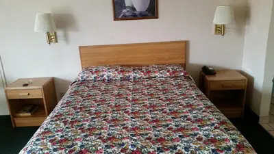 a bed in a hotel room with a floral bedspread at Economy Inn Motel in Sylmar