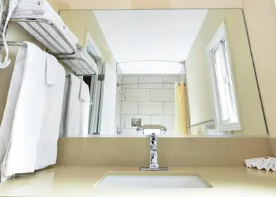 a bathroom with a sink and a large mirror at Sea Rock Inn - Long Beach in Long Beach