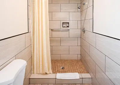 a bathroom with a shower with a toilet and a sink at Sea Rock Inn - Long Beach in Long Beach