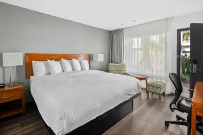 a hotel room with a bed and a desk and chair at Vagabond Inn Glendale in Glendale