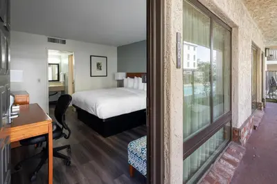 a bedroom with a bed and a desk and a window at Vagabond Inn Glendale in Glendale