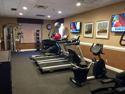 a gym with several tread machines in a room at Hotel d'Lins Ontario Airport in Ontario