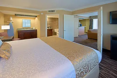 a hotel room with a large bed and a bathroom at Hotel d'Lins Ontario Airport in Ontario