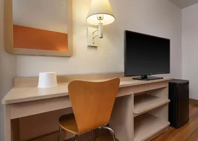 a desk with a monitor and a chair in a room at Motel 6-Buena Park, CA - Knotts Berry Farm - Disneyland in Buena Park
