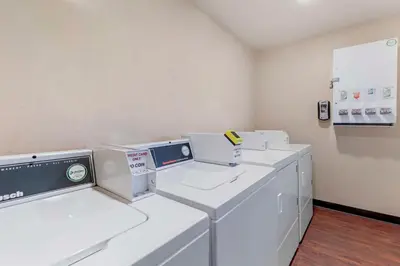 a laundry room with white washers and dryers at Best Western Plus Executive Inn Rowland Height City of Industry in Rowland Heights