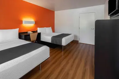 a hotel room with two beds and a desk and a door at Motel 6-Carpinteria, CA - Santa Barbara - South in Carpinteria