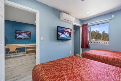 a hotel room with two beds and a desk and a tv at Motel 6-Big Bear Lake, CA in Big Bear Lake