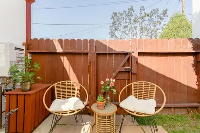 a patio with three chairs and a table and a fence at Casita Gundry- Boutique Hideaway, Quaint Historic Charm in Long Beach