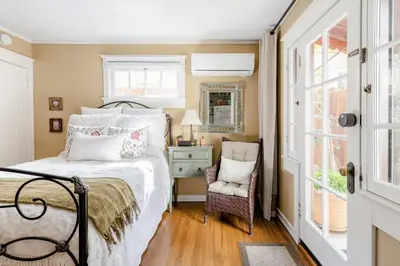 a bedroom with a bed and a chair and a window at Casita Gundry- Boutique Hideaway, Quaint Historic Charm in Long Beach